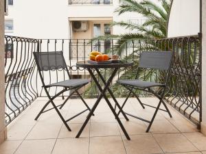 - une table avec 2 chaises et des fruits sur le balcon dans l'établissement Blue Mare Apartment, à Petrovac na Moru