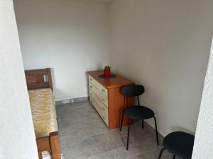 a small room with a dresser and two chairs at Vikendica za odmor in Kloštar Ivanić