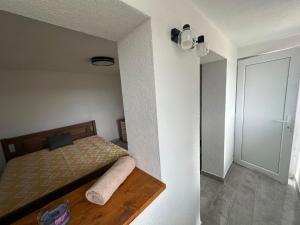a small bedroom with a bed and a door at Vikendica za odmor in Kloštar Ivanić
