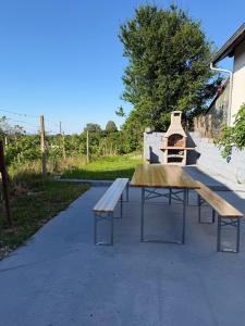 a picnic table with a pizza oven in a park at Vikendica za odmor in Kloštar Ivanić