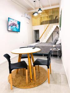 a table and chairs in a room with a bed at Loft Misiones 226 in Puerto Iguazú