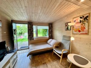 a small living room with a couch and a tv at Domek Dobrawa- 400m do morza in Międzyzdroje