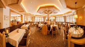 a restaurant with tables and chairs in a room at Hotel Das Urbisgut in Altenmarkt im Pongau