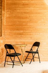 two chairs sitting next to a table in front of a wooden wall at Guest House Adelina in Mestia +54 photos