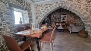 a dining room with a stone wall and a table and chairs at MENELAUS Stone House in Fourní