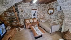 a living room with a couch and a table at MENELAUS Stone House in Fourní