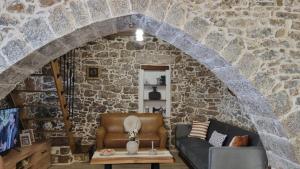 a living room with a stone wall at MENELAUS Stone House in Fourní