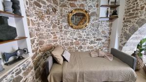 a room with a stone wall with a table and a mirror at MENELAUS Stone House in Fourní