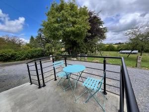 a table and two chairs sitting on a balcony at Maison campagne in Champ-du-Boult