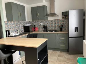 a kitchen with green cabinets and a refrigerator at Maison campagne in Champ-du-Boult