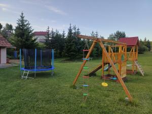 a playground with two blue chairs in the grass at Viola 144 in Han Pijesak