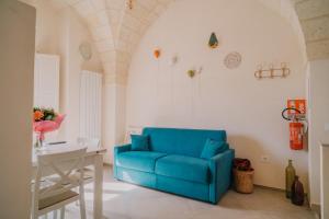 a blue couch in a room with a table at La Dimora del Vicolo - Apartment in Francavilla Fontana