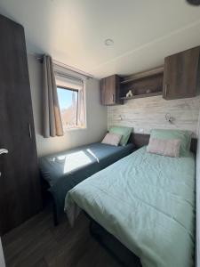 two beds in a small room with a window at Chalet Bois in Torcy-le-Petit