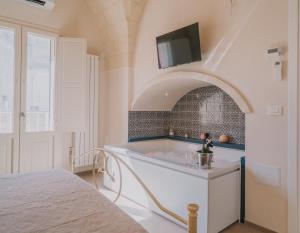 a bathroom with a tub with a tv on the wall at La Dimora del Vicolo - Apartment in Francavilla Fontana +35 photos
