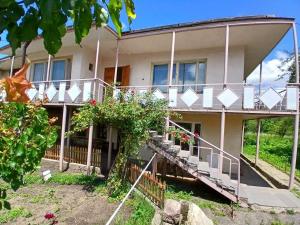 a house with a porch and stairs in front of it at Vardeni Guest house in Dsegh