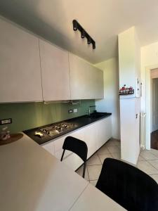 a kitchen with white cabinets and a stove top oven at Ponsy Dream - Firenze, Pisa, Livorno in Ponsacco