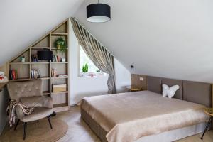 a bedroom with a bed and a chair and a window at Szyszkowa Stodoła in Milejczyce