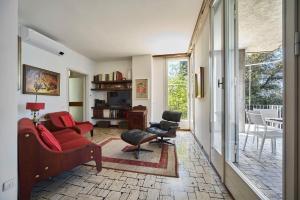a living room with a red couch and chairs at Villa Lucy - Lake view in Varenna