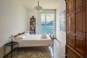 a bedroom with a bed and a large window at Villa Lucy - Lake view in Varenna