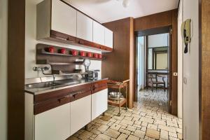 a kitchen with white cabinets and a sink at Villa Lucy - Lake view in Varenna
