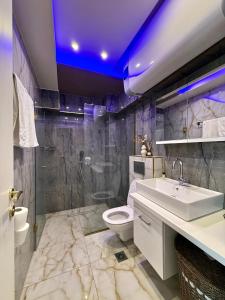a bathroom with a white sink and a toilet at Malama Rooms in Paralia Katerinis