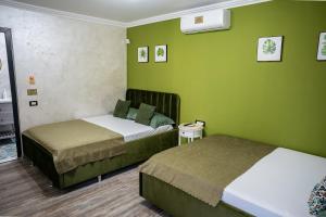 two beds in a room with green walls at VAMA 25- Vama Veche in Vama Veche
