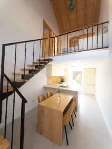 a kitchen and dining room with a wooden table and stairs at PiuPiuStays in Vermelho