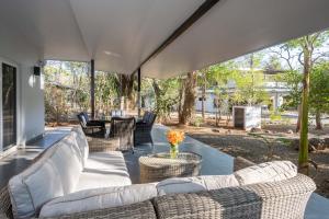 an outdoor patio with wicker furniture and a table at Pazifico Villas in Playa Avellana