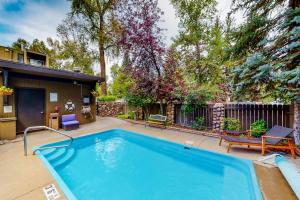a swimming pool in a yard next to a house at Aspen Mountain Lodge in Aspen