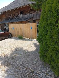 a building with a fence in front of a yard at Studio pr Vok in Lesce