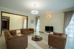 a living room with two chairs and a television at Bella Vista Villas Ltd in Mbarara