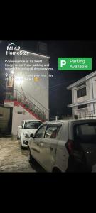 two cars parked in a parking lot next to a building at ML 12 HomeStay in Jakrem