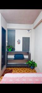 a bedroom with a bed and plants in a room at ML 12 HomeStay in Jakrem