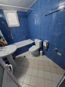 a blue tiled bathroom with a toilet and a sink at Villa Semana Ksamil in Ksamil