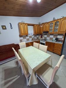 a kitchen with a table and chairs and a couch at Villa Semana Ksamil in Ksamil