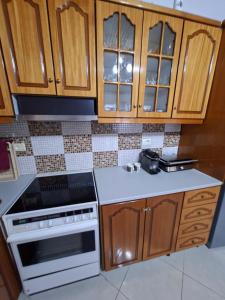 a kitchen with wooden cabinets and a white stove top oven at Villa Semana Ksamil in Ksamil +5 photos