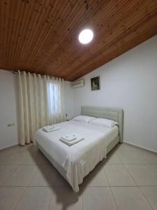a bedroom with a large white bed with a wooden ceiling at Villa Semana Ksamil in Ksamil