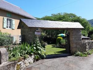 a stone building with a door in a yard at Gîte Pyrénées Ariège Ustou in Ustou