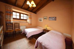 1 dormitorio con 2 camas y 1 silla en Casa Canarina, en Santa Úrsula