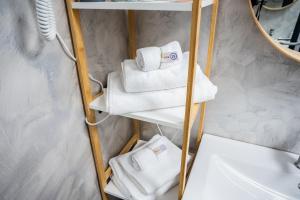 a group of towels on a shelf in a bathroom at VAMA 25- Vama Veche in Vama Veche +142 photos