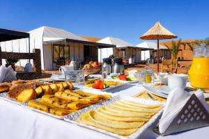 a table with bread and snacks on a table at Aladdin merzouga camp in Merzouga