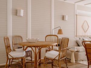 a porch with a table and chairs and a couch at Soho Beach House Canouan in Canouan