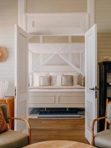 a white bed with two pillows in a room at Soho Beach House Canouan in Canouan +24 photos