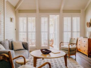 a living room with a couch and a table at Soho Beach House Canouan in Canouan