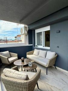 a living room with a couch and chairs and a table at Malama Rooms in Paralia Katerinis +9 photos