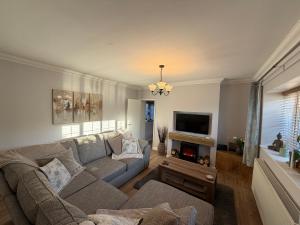 a living room with a couch and a fireplace at 3 bed detatched cottage with onsite parking in Rotherham