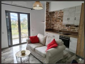 a living room with a white couch and red pillows at Olea Heaven Aliveri in Aliveri