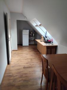 a kitchen with a table and a white refrigerator at Centro-loftas in Telšiai