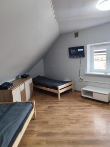 a attic room with two beds and a window at Centro-loftas in Telšiai