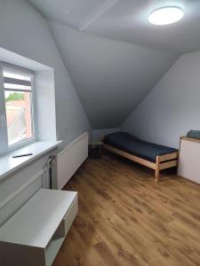 a attic room with a bed and a window at Centro-loftas in Telšiai +3 photos